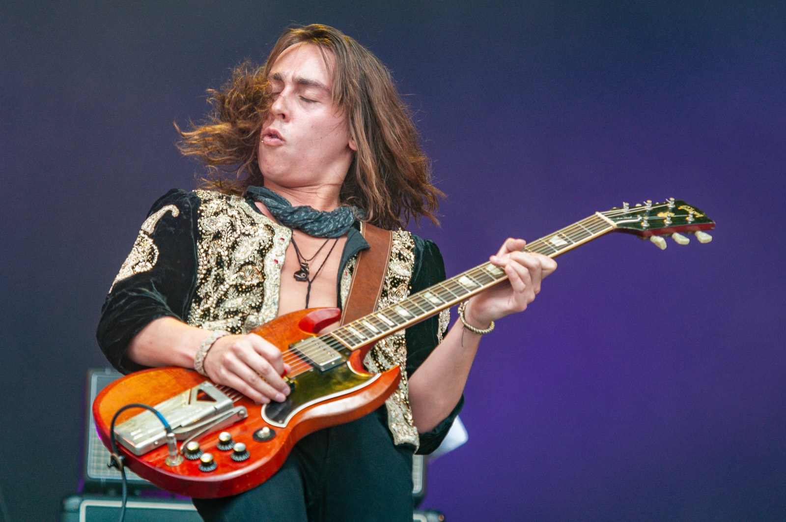 Jake Kiszka lit in purple light with his guitar
